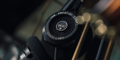 Åben hi-fi hovedtelefon Grado SR80x, nærbillede forfra af højre højttaler med sort gitter og sølvfarvet "SR80 X" logo