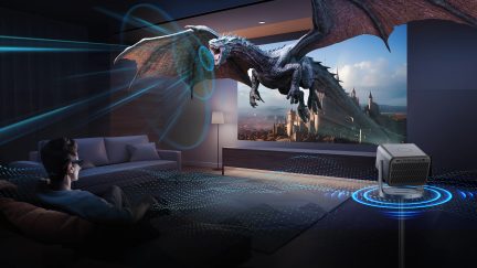 Dark living room, sofa, person sitting, glasses, wall screen, flying dragon, projector, floor lamp, wooden floor