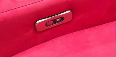 Kromozott USB C típusú csatlakozó élénkpiros szövetfelületen, közelről nagy felbontásban