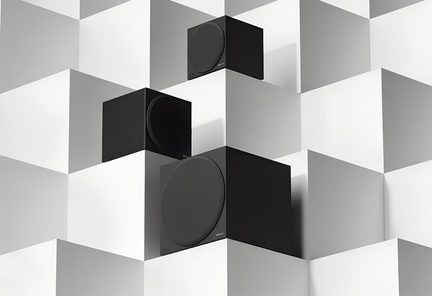 Üç adet siyah, mat ve pürüzsüz malzemeden yapılmış küp şeklinde subwoofer, ön yüzlerinde geniş dairesel ızgaralar bulunan, eğik açıdan görülebilir şekilde, beyaz ve gri küplerden oluşan bir dekor üzerinde yerleştirilmiş