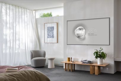Televizor Samsung QE55Q95T 2020 v moderním obývacím pokoji s šedou pohovkou, dřevěným konferenčním stolkem, zelenými rostlinami a bílými závěsy