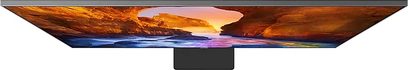 Televizor Samsung QE75Q90R, pohled zepředu, zapnutý displej zobrazující skalnatou krajinu při západu slunce v teplých barvách