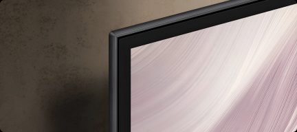 Sort fladskærms-tv set skråt fra siden med tynd kant og abstrakt skærmbillede i lyserød og hvid