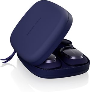 Bowers & Wilkins Px7 S3 v námořnicky modré barvě částečně viditelné v pevné zipové pouzdře z texturované syntetické tkaniny v námořnicky modré barvě, logem v tónu na víku, pohled ze tří čtvrtin
