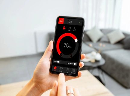 Smartphone, der viser en sort og rød hjemmeautomatiseringsapp til lysstyring på 70 % i en stue