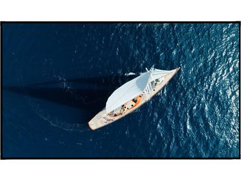 Ecran de proiecție Élysium Screens Edge|One Aurora Pro cu ramă neagră, vedere din față, velier pe ocean albastru