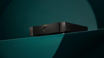 Juodas Marantz hi-fi stiprintuvas, minimalistinis šlifuoto aliuminio fasadas, pastatytas profiliu vienalyčiame žaliame fone