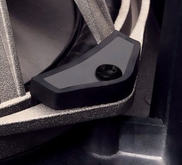 Nærbilde av en svart plastbrakett festet med en svart skrue på en sølvfarget metallstruktur med tekstur.
