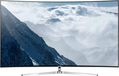 Samsung UE65KS9000-fladskærm viser sneklædte bjerge i skyerne, set forfra på sølvfarvet metalstativ
