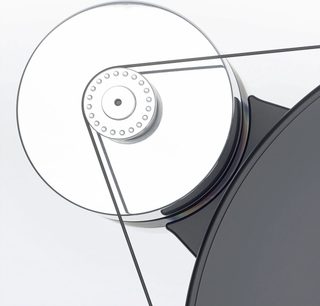 Nærbilde sett ovenfra av hi-fi platespilleren Transrotor Dark Star Silver Shadow, med matt svart sirkulært akrylplate og polert metalltrinse forbundet med en tynn svart reim