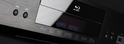Sort Blu-ray-afspiller med blå "HOME MENU"-skærm og knapper på forsiden, set fra en trekvartvinkel