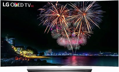 LG OLED 4K TV viser et farverigt festfyrværkeri over en kystby om natten
