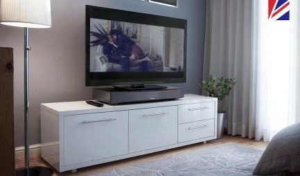 Hvidt TV-møbel med 3 skuffer, fladskærm der viser et sort-hvidt foto af to personer siddende på en sofa