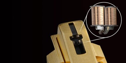 Hi-fi phono přenoska ve zlatém pouzdře s detailním pohledem na vnitřní dvojité měděné cívky