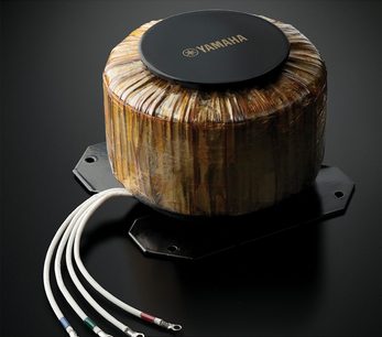 Yamaha M-5000 Leistungsverstärker in Schwarz, Aufsicht, zylindrisches Gehäuse aus gestreiftem Holz, Anschlüsse und Kabel an der Rückseite