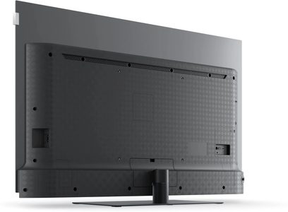 Televisor Loewe We. SEE 65 OLED dc preto, vista traseira em ligeiro ângulo, parte traseira texturizada com conectores laterais