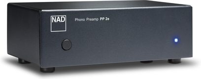 NAD PP2e phono-voorversterker in een rechthoekige matantraciet metalen behuizing, gezien vanuit een drie-kwart voorzijde rechts, met een gescreende NAD-logo aan de linkerkant, een centrale zwarte ronde knop en een blauwe LED-indicator aan de rechterkant, rustend op vier cilindrische voetjes.