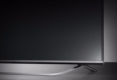 LG 49UF778V ultra HD 4K-fladskærm set forfra i en let sidevinkel på en sølvfarvet, buet minimalistisk fod