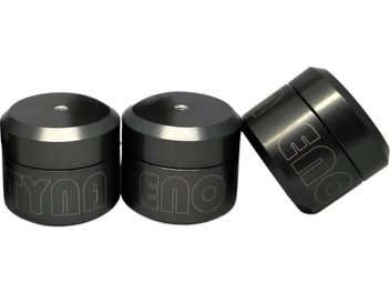 Set aus drei zylindrischen Aktyna ENO Anti-Vibrationsdämpfern aus anthrazitgrauem Metall mit matter Oberfläche, abgeschrägtem Oberteil mit kleinem zentralen Loch und kontrastierend eingravierter Beschriftung, leicht von vorne in Perspektive aufgenommen