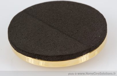 Svart skumgummiskive med tett struktur, flat overside, omgitt av en skinnende gyllen ring, sett ovenfra mot hvit bakgrunn