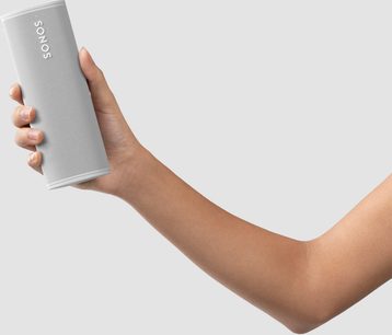 Sonos Roam Lunar White speaker held in a hand, front and side view, rounded rectangular shape, white grille