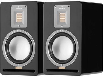 Paire d’enceintes bibliothèque AudioVector QR1 SE noir, coffrets en bois laqué noir vue de trois-quarts avant, dotées d’un woofer aluminium cerclé argent, d’un tweeter ruban rectangulaire sur plaque métal grise et d’une fente bass-reflex horizontale inférieure