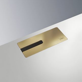 Rectangular gold metal plate embedded in a white surface, elongated slot, oblique view, 'clic' logo