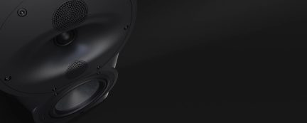 Altavoz negro con tweeter circular, medio cónico, woofer redondo, tornillos visibles, superficie lisa, fondo negro uniforme