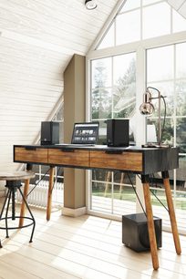 Interior modern cu birou din lemn, laptop, boxe, lampă de masă design și ferestre mari
