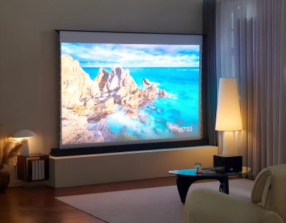 Schermo di proiezione motorizzato di grande formato in un soggiorno moderno con immagine di paesaggio marino luminoso