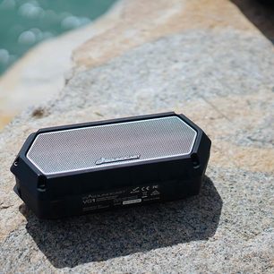 Trådløs, tilsluttet højttaler Soundcast VG1, sort, rektangulær, med metalrist på toppen, placeret på sand