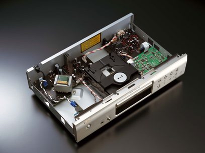 Denon DCD-510 sort CD-afspiller, indvendigt perspektivisk udsigt, låget åbent, elektroniske og mekaniske komponenter synlige