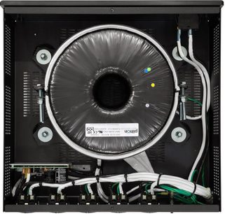 Torus Power RM 8 CE strømrenser i sølv sett ovenfra, med en sentral toroidal transformator og hvite kabler tilkoblet