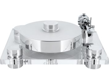 Hi-Fi vinylový přehrávač Transrotor Bellini RB330 ve stříbrné a průhledné barvě, pohled zepředu, kruhový kovový talíř s leštěným povrchem a přítlačným kotoučem, průhledný akrylový podstavec na čtyřech válcových nohách a chromovaný raménko na pravé straně