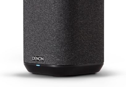 Črni brezžični zvočnik Denon Home 150, sprednja stran iz temne mrežaste tkanine, zaobljeno ohišje z modro LED-diodo