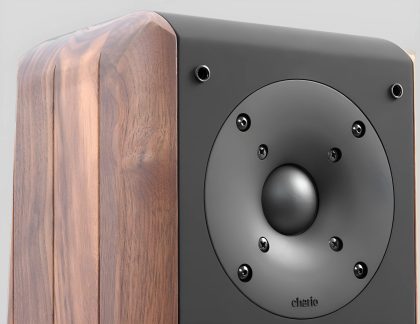 Wooden enclosure with a black circular speaker and six visible screws on a black front panel