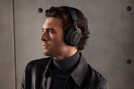 Venstre profil af en mand iført et sort circum-auralt headset i plast og metal, Bowers & Wilkins-logo synligt