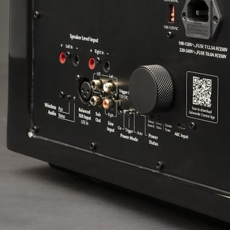 Černý zadní panel s audio konektory, tlačítky, RCA porty, XLR konektory, QR kódem, bílými nápisy a rýhovaným tlačítkem