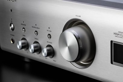 Denon PMA-900HNE sølv hi-fi stereoanlegg. Frontpanel med knapper, volumkontroll og hodetelefonutgang. Nærbilde