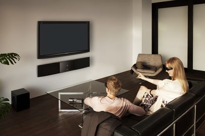 Panasonic SC-BFT800EGK hjemmebiografsystem med soundbar, basrør og to personer siddende på en sofa