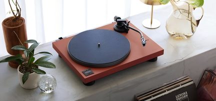 Matte murstensorange vinylplade, sort drejeskive med filtunderlag, S-formet metalarm, rektangulære knapper, trekvartsfoto fra oven