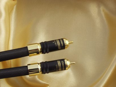 To sorte og guldfarvet Choseal CRA-3011 stereo RCA-RCA-kabler i satinvævet stof, nærbillede og delvist syn