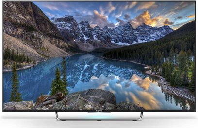 Sony KDL-55W809C TV-skærm, der viser et bjerglandskab med en sø, der reflekterer skyer og grantræer på bredden
