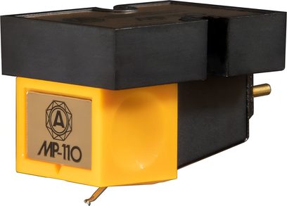 Testina hi-fi Nagaoka MP-110 in primo piano, corpo rettangolare in plastica gialla e nera, placca frontale metallizzata dorata con logo e scritta, puntina visibile sotto il corpo, vista a tre quarti
