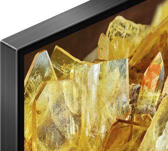 Sony XR65X90L, øverste venstre hjørne, sort metalramme, skærm viser gule krystaller, set fra vinkel