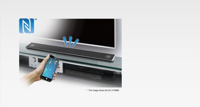 Panasonic SC-HTB880 sort soundbar, set forfra, med en hånd der holder en smartphone foran kontrolpanelet