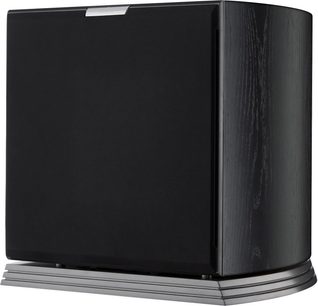 Subwoofer AudioVector RSUB Arreté negro en chapa de madera con gran rejilla frontal de tela, laterales ligeramente curvados con vetas y base metálica gris laminada, vista en tres cuartos desde el frente derecho
