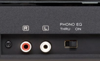 Zadní část černého audio zařízení s červenými a bílými RCA konektory, konektorem L, vypínačem ON a nápisem "PHONO EQ THRU ON"
