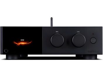 Audio prevodník DAC Audiolab D9 v čiernom kovovom prevedení, pohľad spredu, obdĺžnikové puzdro na nožičkách s lesklým displejom vľavo zobrazujúcim oranžový motív a text D9, dva veľké otočné ovládače na výber a hlasitosť v strede, tlačidlo napájania a LED vpravo, tenká vertikálna anténa v pozadí