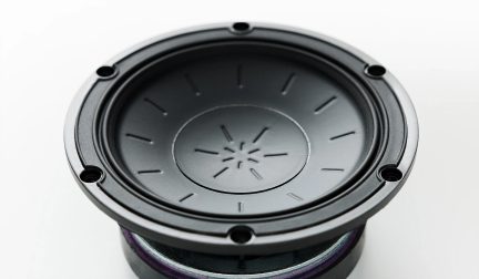Difuzor rotund negru văzut din unghi de trei sferturi, cu membrană cu modele radiale și șase orificii de fixare pe circumferință